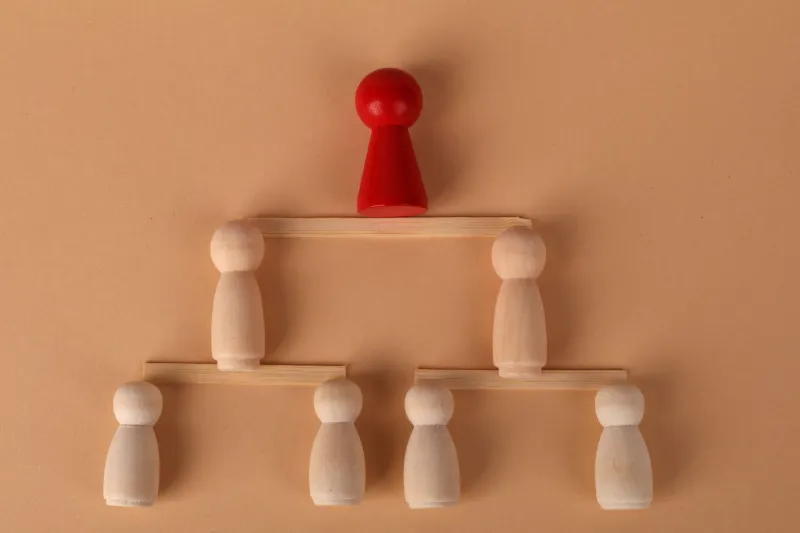When Flat Becomes Frozen: How Async-First Organizations Quietly Rebuild the Hierarchies They Tried to Dismantle